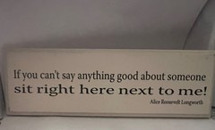 White decorative wood sign features black typography with a famous quote