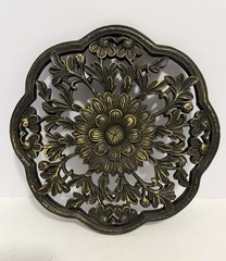 floral wall medallion featuring a black and gold patina finish